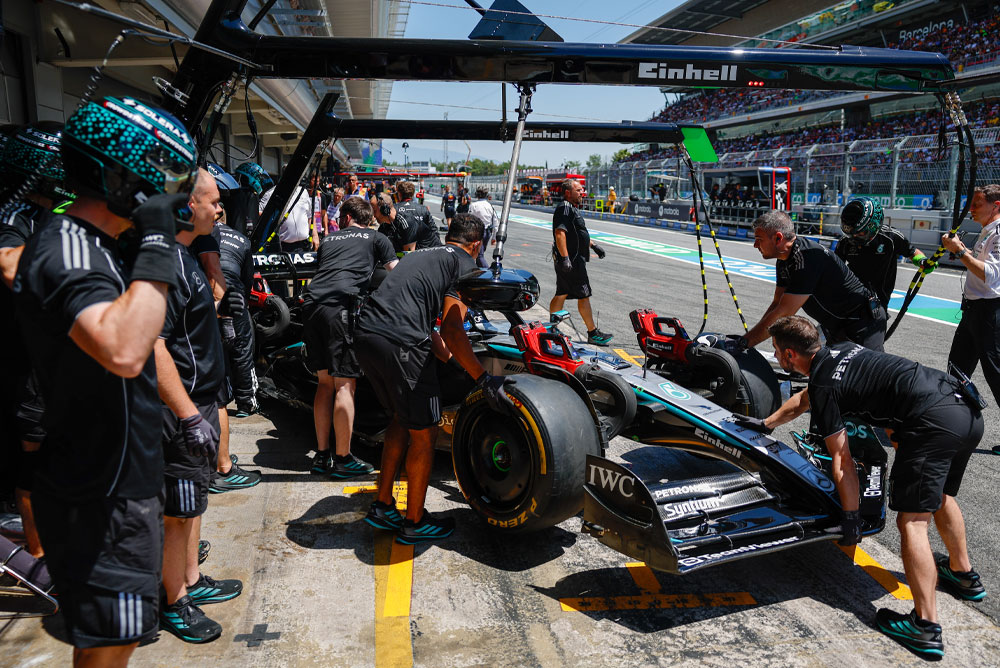 Formula 1 automobil se gura u garažu.