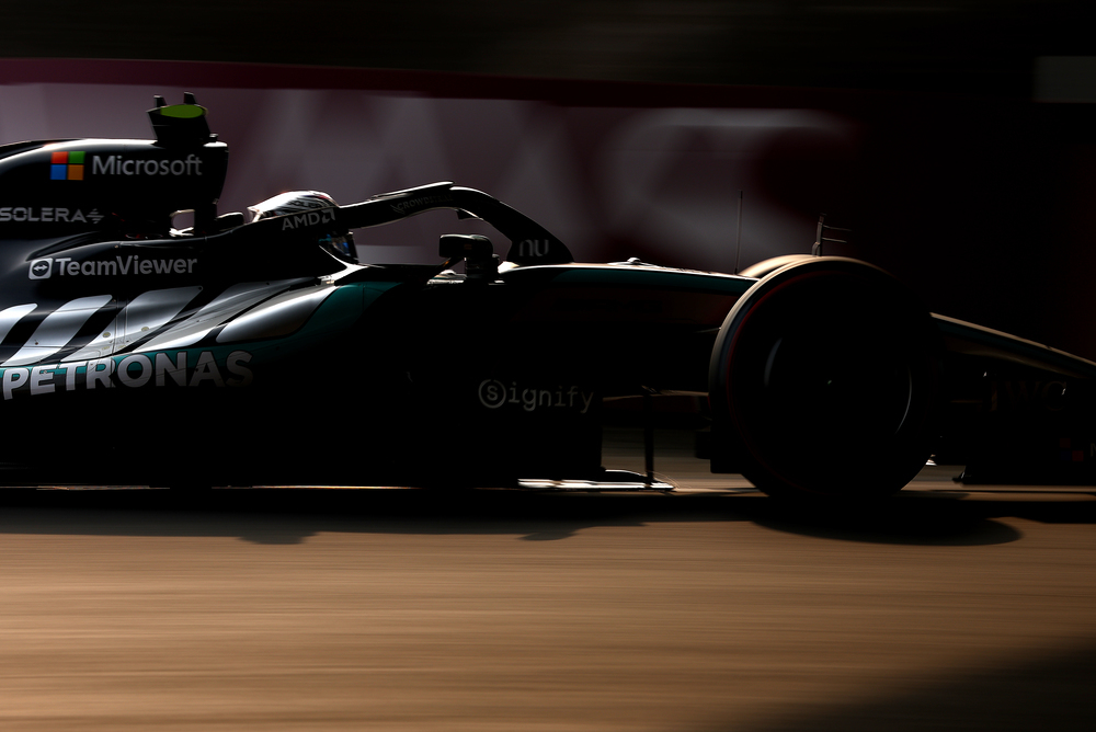 Mercedes F1 bolid na stazi pri slabom svetlu