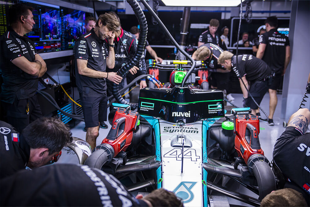 Formula 1 mercedes mechanics standing around the race car