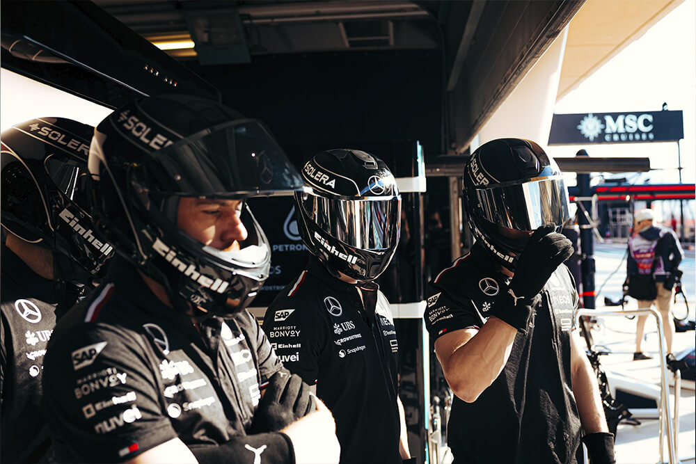 A few formula 1 mercedes mechanic standing in the workshop